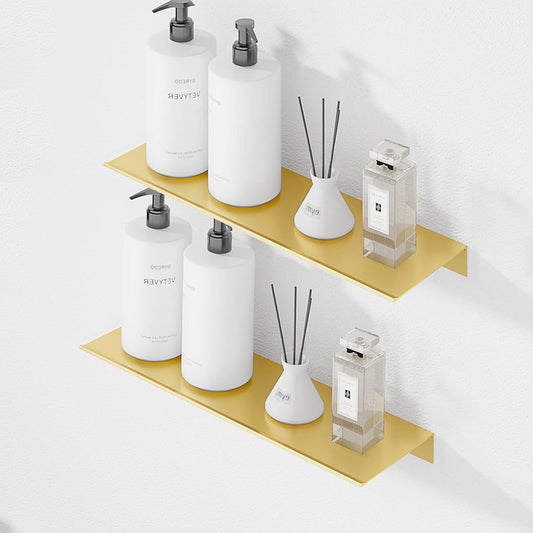 Gold shelves with white bottles and decorative items on a light gray dorm wall
