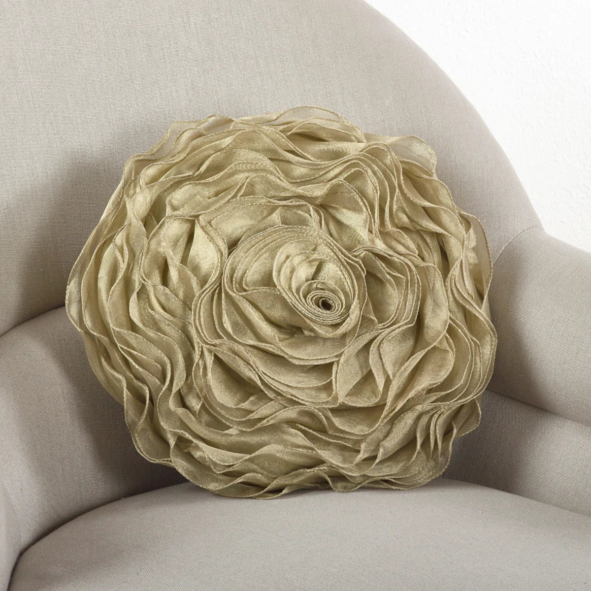 Round gold rose throw pillow with layered satin petals on a cream armchair, perfect for glam or coquette dorm décor