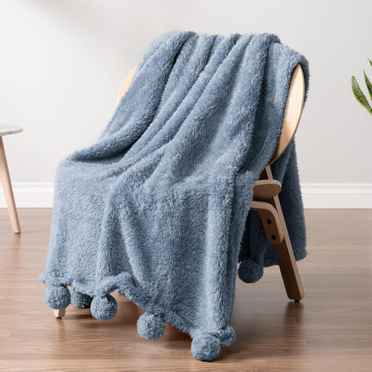 Soft sherpa blanket with pom poms perfect for coastal dorm decor