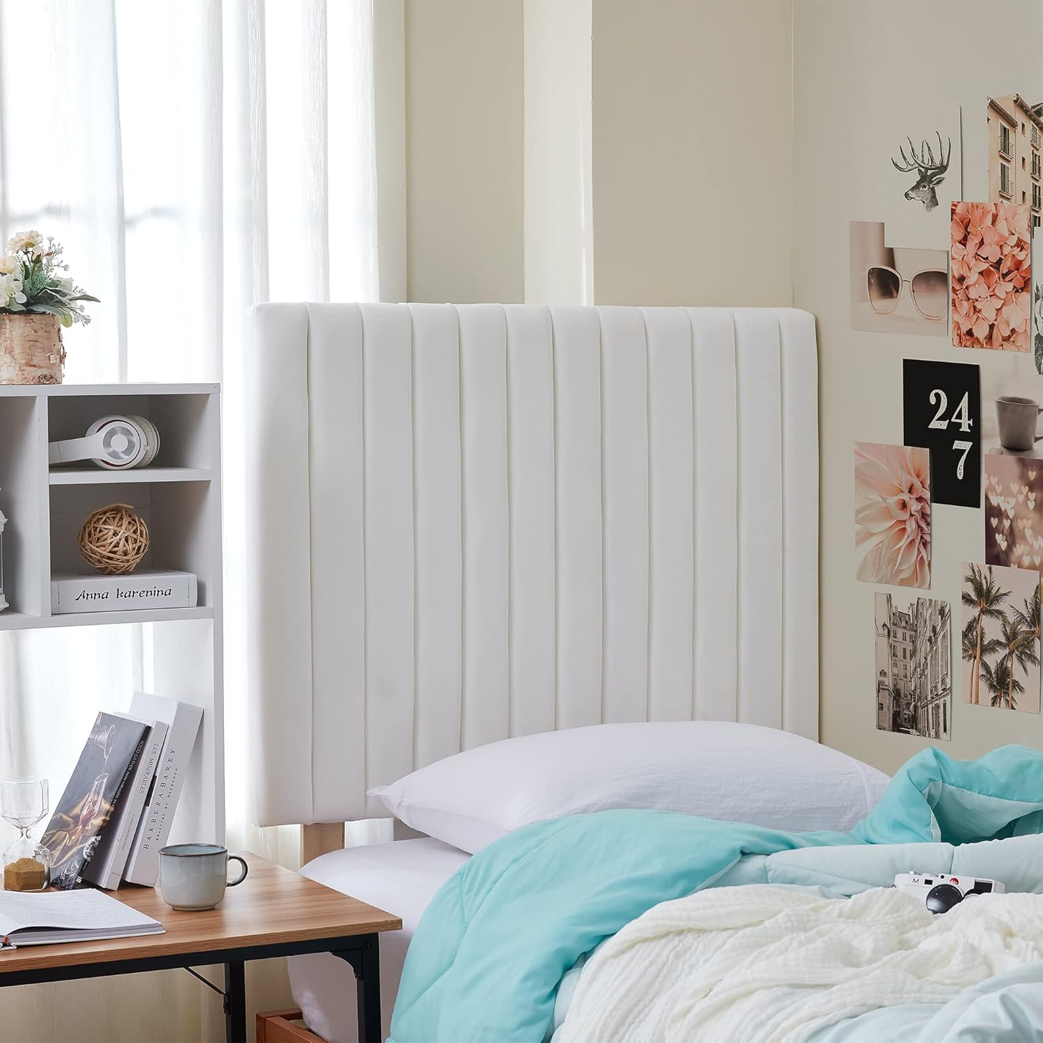 Dorm room with a white upholstered headboard, turquoise bedding, and a wooden nightstand. Dorm Decor